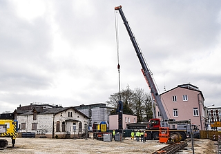 Der Fahrer des grau-roten Krans wird ein Probegewicht auf die Gründungspfähle des Rathauses fallen lassen. (Foto: Frank)