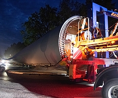 Ein Schwerlasttransporter fährt durch den Kreisverkehr zwischen Klein und Groß Nordende. Das bepflanzte Rondell war eigens für die Aktion zu etwa einem Viertel abgetragen worden, damit genügend Platz für die Rotorblätter und Fahrzeuge besteht. (Foto: Frank)