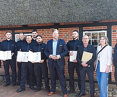 Feierten den erfolgreichen Abschluss der Ausbildung: Justizstaatssekretär Otto Carstens (Siebter von links), Stefan Ruppert (Neunter von links, Leiter der Abschiebungshafteinrichtung Glückstadt), Johanna Hampel (Mitarbeiterin im Justizministerium), Alex Krug (rechts, Ausbildungsleiter der Abschiebungshafteinrichtung Glückstadt) und die neuen Mitarbeiter der neuen Abschiebehafteinrichtung Glückstadt. (Foto: Ministerium für Justiz und Gesundheit)
