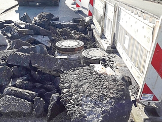 Der beschädigte Schmutzwasserschacht (links im Bild) liegt in der Fahrbahn der B431 in Richtung Uetersen. Fast in der Mitte der Straße  verläuft ein Niederschlagswasserschacht (rechts im Bild), der für die Reparaturarbeiten entfernt werden muss. (Foto: AZV Südholstein)