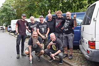 Wacken-Fans aus Uelzen auf dem Rastplatz Forst Rantzau: Micha (hinten von links), Uwe, Boller, Ralf, Strucki, Thomas Rogge sowie Oeli (vorn links) und Timo. Sie wollen auf der Gewerbefläche eines Kumpels in Itzehoe unterkommen. (Foto: Frank)