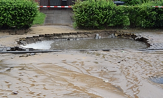 Durch den Wasserdruck wurde ein großes Loch in den Gehweg an der Reuterstraße gerissen. (Foto: Frank)