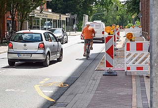 Die Bremslichter des VW Polo leuchten auf. Der Fahrer hatte in der Berliner Straße Richtung Krückaubrücke zum Überholen angesetzt – wahrscheinlich um den Mindestabstand von 1,50 Metern zu dem Radler einzuhalten. Der Polo-Fahrer lenkte seinen Wagen bereits mit zwei Rädern auf die Gegenfahrbahn, musste aber wegen dem Gegenverkehr bremsen und wieder einscheren. Zuvor war der Radfahrer der gelben Markierung auf die Berliner Straße gefolgt, da der Geh- und Radweg Richtung Krückaubrücke gesperrt ist. (Foto: Frank)